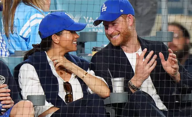Prince Harry, right, and Meghan Markle, Duke and Duchess of Sussex, sit during the eighth inning in Game 4 of baseball's World Series between the Los Angeles Dodgers and the Toronto Blue Jays in Los Angeles, Tuesday, Oct. 28, 2025. (Frank Gunn/The Canadian Press via AP)