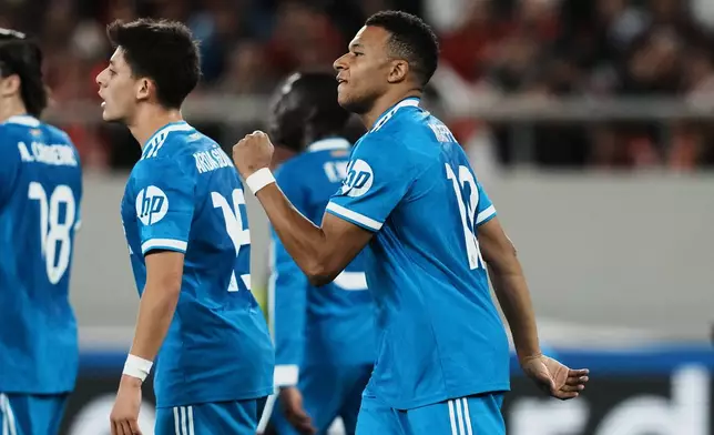 Real Madrid's Kylian Mbappe, right, celebrates scoring his side's second goal during the Champions League opening phase soccer match between Olympiacos and Real Madrid in Piraeus port, near Athens, Greece, Wednesday, Nov. 26, 2025. (AP Photo/Thanassis Stavrakis)