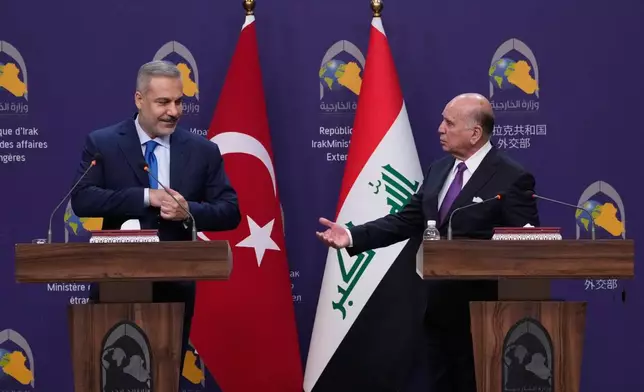 Turkish Foreign Minister Hakan Fidan, left, listens to his Iraqi counterpart Fuad Hussein during a news conference after a meeting at the foreign ministry in Baghdad, Iraq, Sunday, Nov. 2, 2025. (AP Photo/Hadi Mizban)