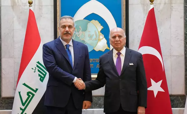 Iraqi Foreign Minister Fuad Hussein, right, shakes hands with Turkish Foreign Minister Hakan Fidan, in Baghdad, Iraq, Sunday, Nov. 2, 2025. (AP Photo/Hadi Mizban)