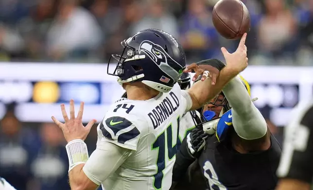 Seattle Seahawks quarterback Sam Darnold, left, is hit by Los Angeles Rams linebacker Jared Verse for an incomplete pass during the second half of an NFL football game Sunday, Nov. 16, 2025, in Inglewood, Calif. (AP Photo/Gregory Bull)