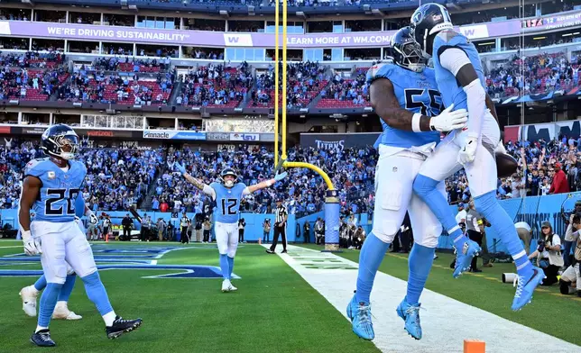 Tennessee Titans wide receiver Van Jefferson, right, celebrates with offensive tackle JC Latham (55) after Jefferson scored a touchdown against the Houston Texans during the second half of an NFL football game on Sunday, Nov. 16, 2025, in Nashville, Tenn. (AP Photo/John Amis)
