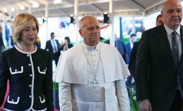 Pope Leo XIV, center, is escorted by Lebanese President Joseph Aoun, right, First Lady Nehmat Aoun before arrival ceremony at Beirut International Airport in Beirut, Lebanon, Sunday, Nov. 30, 2025.(AP Photo/Hussein Malla)