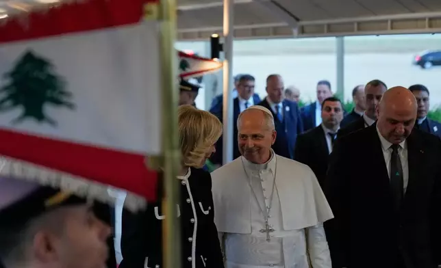 Pope Leo XIV is welcomed by Lebanese President Joseph Aoun, right, and First Lady Nehmat Aoun upon his arrival to Beirut International Airport ,in Beirut, Lebanon, Sunday, Nov. 30, 2025 (AP Photo/Hussein Malla)