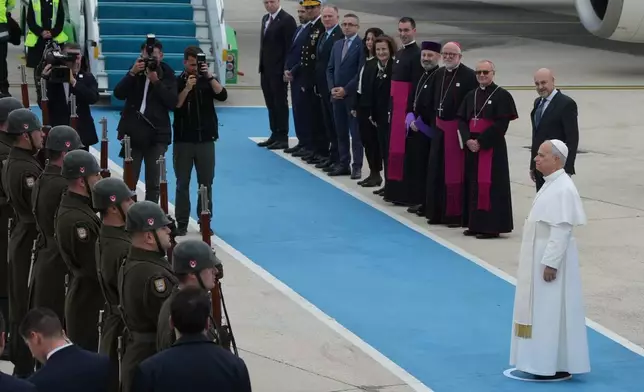 Pope Leo XIV reviews an honor guard during a farewell ceremony before boarding a plane bound to Beirut, Lebanon, at Ataturk airport, in Istanbul, Turkey, Sunday, Nov. 30, 2025. (AP Photo/Dilara Acikgoz)