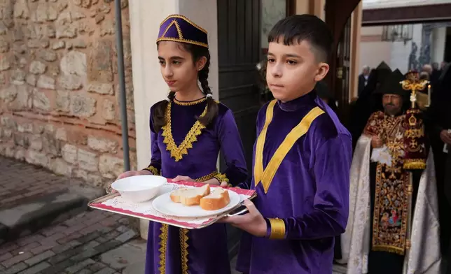 Children and Armenian Patriarch of Constantinople Archbishop Sahag II Mashalian, background right, wait for Pope Leo XIV to celebrate a liturgy at the Armenian Apostolic Cathedral, in Istanbul, Turkey, Sunday, Nov. 30, 2025. (AP Photo/Dilara Acikgoz)