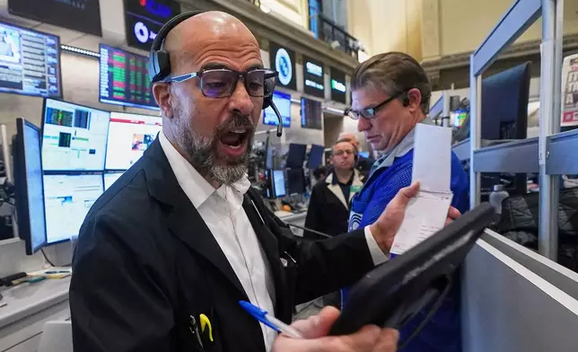 Options trader Steven Rodriguez, left, works on the floor of the New York Stock Exchange, Monday, Nov. 24, 2025. (AP Photo/Richard Drew)