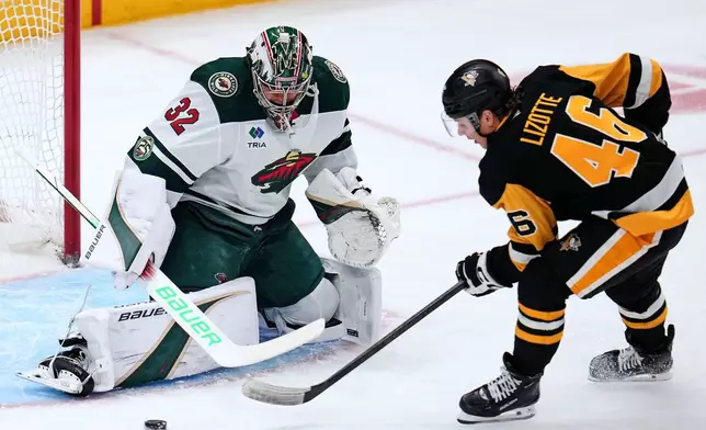 Pittsburgh Penguins' Blake Lizotte (46) cannot get off a shot in front of Minnesota Wild goaltender Filip Gustavsson (32) during the first period of an NHL hockey game in Pittsburgh, Friday, Nov. 21, 2025. (AP Photo/Gene J. Puskar)