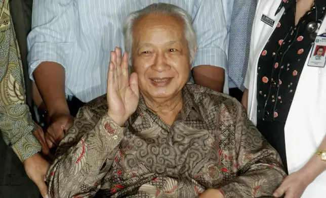 FILE - Former Indonesian President Suharto waves to journalists as he leaves a hospital after being treated for intestinal bleeding, in Jakarta, Indonesia, on May 5, 2004. (AP Photo/Dita Alangkara, File)
