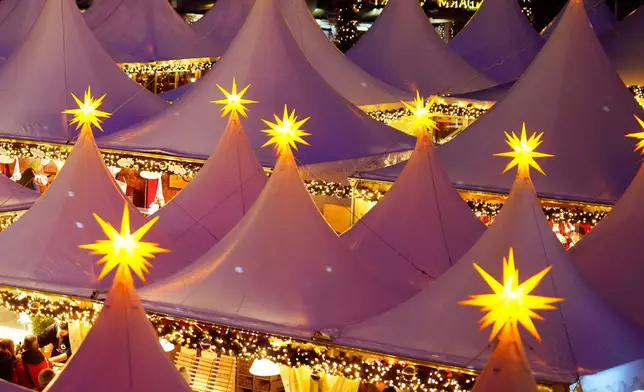 FILE - Lights illuminate the Christmas market at the Gendarmen Markt square in Berlin, Germany, Nov. 24, 2025. (AP Photo/Markus Schreiber, File)