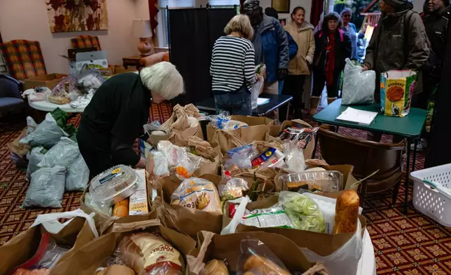 FILE - Volunteers work to package meals during the food pantry service at Calvary Episcopal Church on Oct. 30, 2025, in Louisville, Ky. (AP Photo/Jon Cherry, file)