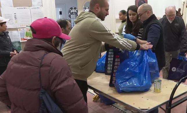 A volunteer helps gather bags of food at the Holy Apostles Soup Kitchen and Pantry in the Chelsea neighborhood of Manhattan in New York, on Wednesday, Oct. 29, 2025. (AP Photo/Joseph B. Frederick)