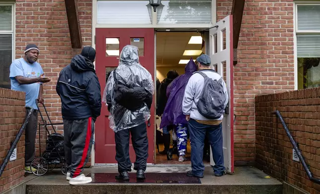 FILE - Community members wait in line to enter the food pantry service at Calvary Episcopal Church on Oct. 30, 2025, in Louisville, Ky. (AP Photo/Jon Cherry, file)