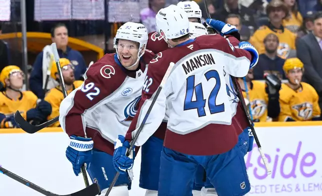 Colorado Avalanche left wing Gabriel Landeskog (92) celebrates a goal by defenseman Brent Burns, not visible, along with Colorado defenseman Josh Manson (42) during the first period of an NHL hockey game against the Nashville Predators, Saturday, Nov. 22, 2025, in Nashville, Tenn. (AP Photo/John Amis)