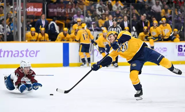 Nashville Predators defenseman Nick Blankenburg (37) takes a shot as Colorado Avalanche center Parker Kelly dives to defend during the second period of an NHL hockey game Saturday, Nov. 22, 2025, in Nashville, Tenn. (AP Photo/John Amis)