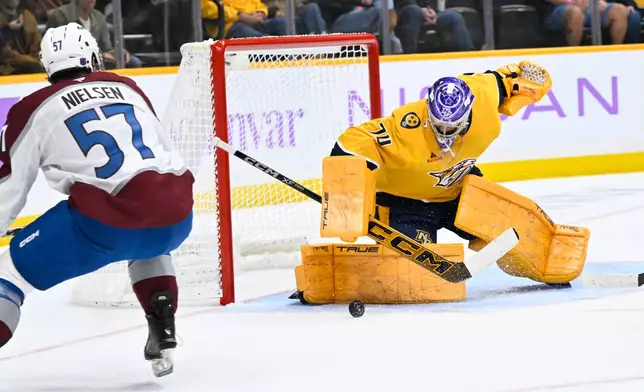 Nashville Predators goaltender Juuse Saros (74) makes a save on a shot by Colorado Avalanche center Tristen Nielsen (57) during the first period of an NHL hockey game Saturday, Nov. 22, 2025, in Nashville, Tenn. (AP Photo/John Amis)