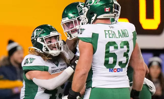 Saskatchewan Roughriders' A.J. Ouellette (45), left, celebrates his touchdown with teammates while taking on the Montreal Alouettes during first half CFL football action in the Grey Cup in Winnipeg, Manitoba, Sunday, Nov. 16, 2025. (Darryl Dyck/The Canadian Press via AP)