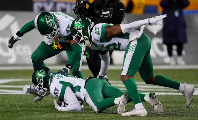 Saskatchewan Roughriders' Marcus Sayles (8), bottom, celebrates with teammates after recovering a fumble from Montreal Alouettes' Shea Patterson (7) during second half CFL football action in the Grey Cup in Winnipeg, Manitoba, Sunday, Nov. 16, 2025. (Frank Gunn/The Canadian Press via AP)