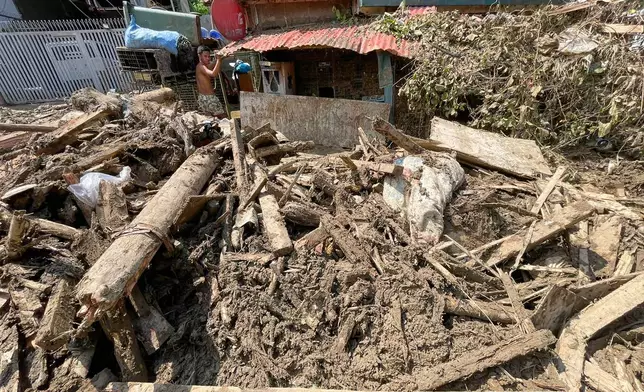 Debris lays outside a house as residents return to their flood damaged homes in Bacayan, Cebu province, central Philippines on Friday Nov. 7, 2025 after Typhoon Kalmaegi devastated the province and claimed lives. (AP Photo/Jacqueline Hernandez)
