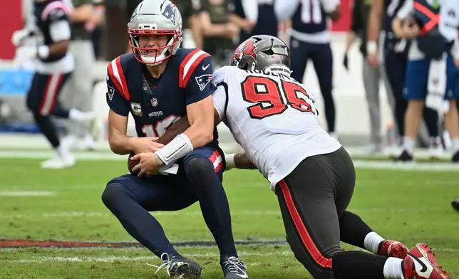 Tampa Bay Buccaneers defensive end Elijah Roberts (95) sacks New England Patriots quarterback Drake Maye (10) during the first half of an NFL football game Sunday, Nov. 9, 2025, in Tampa, Fla. (AP Photo/Jason Behnken)