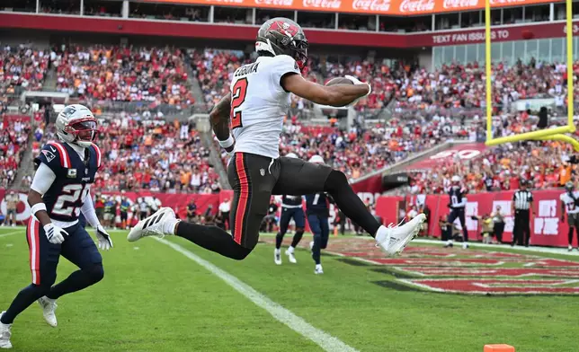 Tampa Bay Buccaneers wide receiver Emeka Egbuka (2) scores a touchdown against the New England Patriots during the first half of an NFL football game Sunday, Nov. 9, 2025, in Tampa, Fla. (AP Photo/Jason Behnken)