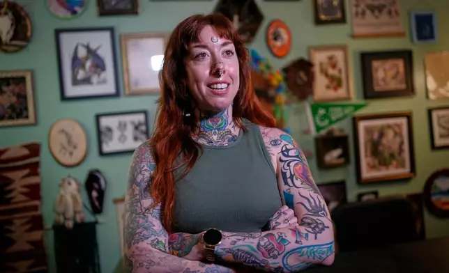 Tattoo artist Mischa Ostberg talks with a visitor at the Ghost Rose Tattoo parlor, Nov. 3, 2025, in Ellsworth, Maine. (AP Photo/Robert F. Bukaty)