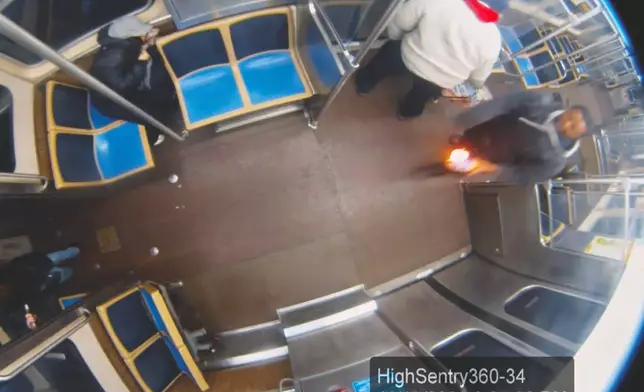 This still image taken from Chicago Transit Authority surveillance footage and included in a federal court record shows a man who federal authorities identified as Lawrence Reed holding a flaming bottle and approaching a passenger, far left, on Monday, Nov. 17, 2025, on a Chicago Blue Line train. (Chicago Transit Authority/U.S. District Court Northern District of Illinois via AP)