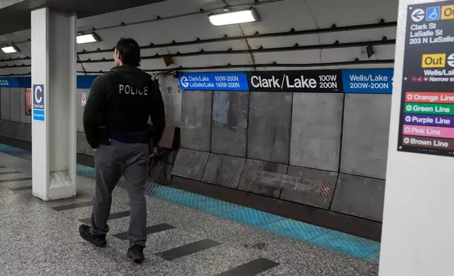 A Chicago police officer patrols the Clark Street and Lake Street Blue Line stop where a man doused a woman in liquid and set her on fire on the train Monday night, Tuesday, Nov. 18, 2025, in Chicago. (AP Photo/Erin Hooley)
