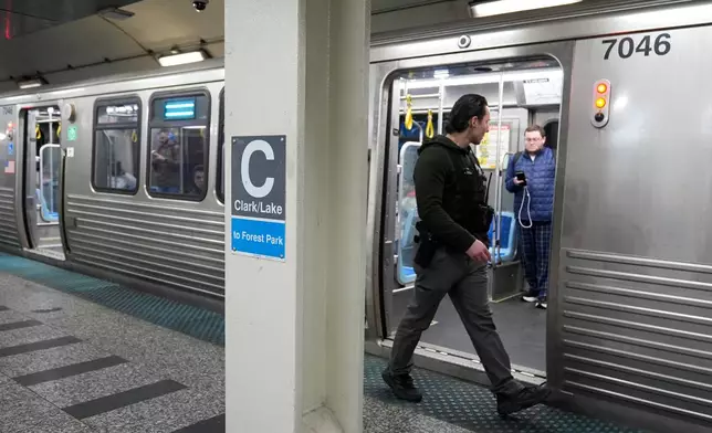 A Chicago police officer patrols the Clark Street and Lake Street Blue Line stop where a man doused a woman in liquid and set her on fire on the train Monday night, Tuesday, Nov. 18, 2025, in Chicago. (AP Photo/Erin Hooley)