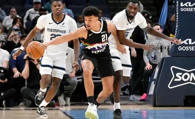 Denver Nuggets forward Spencer Jones (21) reaches for the ball ahead of Memphis Grizzlies forward Cedric Coward and guard Vince Williams Jr. in the first half of an NBA basketball game, Monday, Nov. 24, 2025, in Memphis, Tenn. (AP Photo/Brandon Dill)