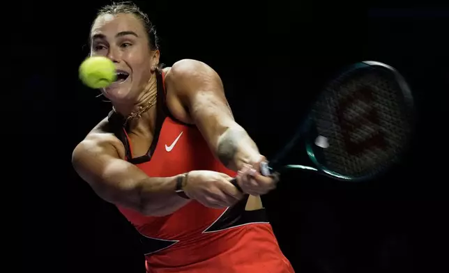 Aryna Sabalenka of Belarus plays a backhand return to Coco Gauff of the United States during their women's singles match at the WTA tennis finals in Riyadh, Saudi Arabia, Thursday, Nov. 6, 2025. (AP Photo/Fatima Shbair)