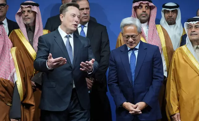Elon Musk speaks with Nvidia CEO Jensen Huang, as they attend the Saudi Investment Forum at the Kennedy Center, Wednesday, Nov. 19, 2025, in Washington. (AP Photo/Evan Vucci)