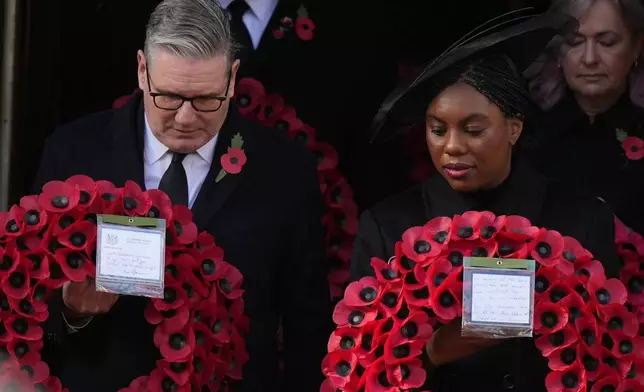 Britain's Prime Minister Keir Starmer and Kemi Badenoch, Leader of Britain's Conservative Party, carry a wreath during the Remembrance Sunday Service at the Cenotaph in London, Sunday, Nov. 9, 2025.(AP Photo/Alastair Grant, Pool)