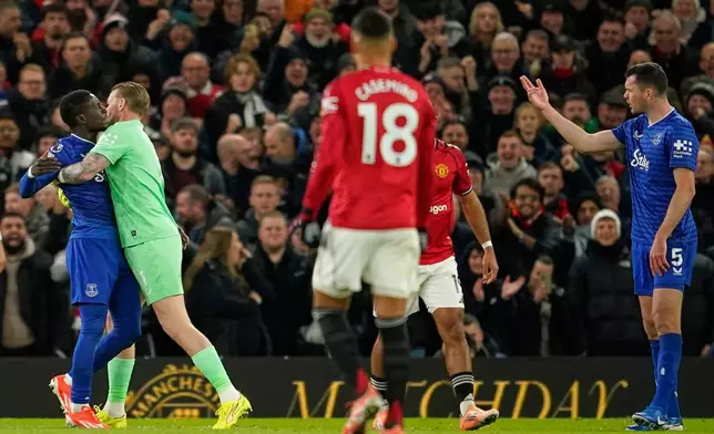 Everton's Idrissa Gueye, left, is held back by teammate Jordan Pickford as he argues with Michael Keane after getting a red card during the English Premier League soccer match between Manchester United and Everton in Manchester, England, Monday, Nov. 24, 2025. (AP Photo/Dave Thompson)
