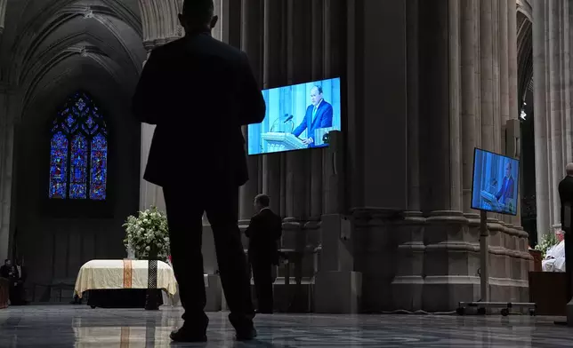 Former President George W. Bush is seen speaking a tribute on the monitors during the funeral for former Vice President Dick Cheney at the Washington National Cathedral, Thursday, Nov. 20, 2025 in Washington. (AP Photo/Matt Rourke)