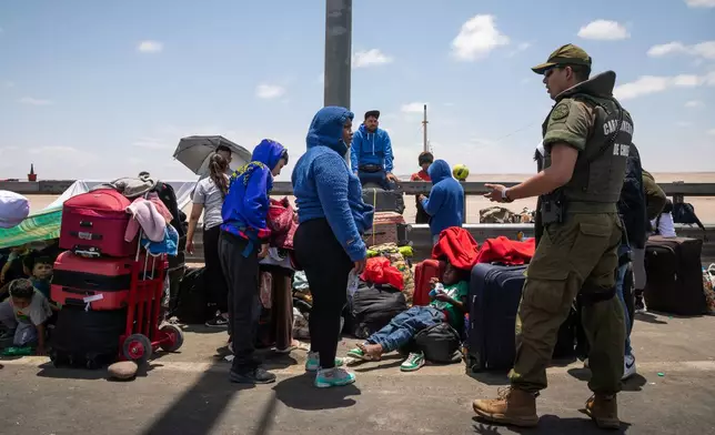 Migrants wait to cross into Peru at the Chacalluta border crossing point in Arica, Chile, Friday, Nov. 28, 2025. (AP Photo/Ibar Silva)