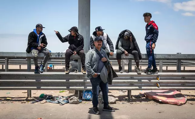 Migrants wait to cross into Peru at the Chacalluta border crossing point in Arica, Chile, Friday, Nov. 28, 2025. (AP Photo/Ibar Silva)