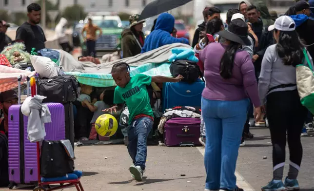 Migrants wait to cross into Peru at the Chacalluta border crossing point in Arica, Chile, Friday, Nov. 28, 2025. (AP Photo/Ibar Silva)