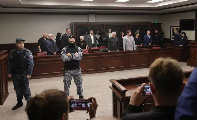 Eight men tried on terrorism charges over a 2022 attack on the bridge linking Russia to Moscow-annexed Crimea stand in a glass cage in a military court in Rostov-on-Don, Russia, Thursday, Nov. 27, 2025. (AP Photo)
