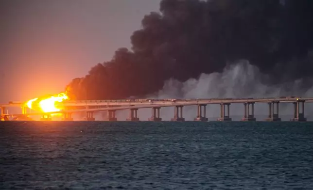 FILE - Flame and smoke rise from Crimean Bridge connecting Russian mainland and Crimean peninsula over the Kerch Strait, in Kerch, Crimea, on Oct. 8, 2022. (AP Photo, File)
