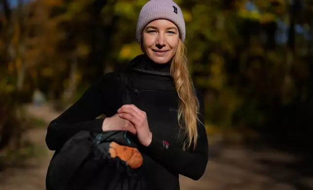 Surfer Lena Stillner looks into the camera at the Eisbach, where the famous wave usually forms, in Munich, Germany, Wednesday, Nov. 5, 2025. (AP Photo/Matthias Schrader)