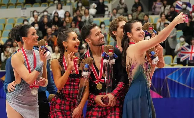 Gold medalists Lilah Fear and Lewis Gibson of Britain, center, silver medalists Charlene Guignard and Marco Fabbri of Italy, left, and bronze medalists Caroline Green and Michael Parsons of the U.S., pose for a selfie after the award ceremony for the Ice Dance Free Dance at ISU Grand Prix of Figure Skating - NHK Trophy in Kadoma, east of Osaka, western Japan, Saturday, Nov. 8, 2025. (AP Photo/Hiro Komae)