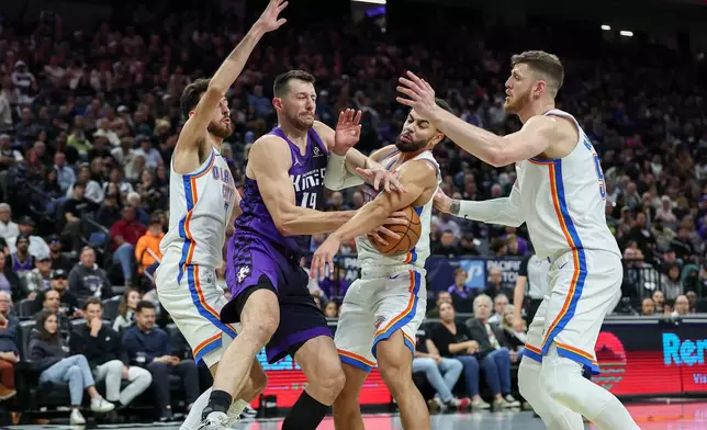 Sacramento Kings forward Drew Eubanks, second to left, and Oklahoma City Thunder guard Ajay Mitchell, second to right, battle for the rebound and during the first half of an NBA Cup basketball game, Friday, Nov. 7, 2025, in Sacramento, Calif. (AP Photo/Sara Nevis)
