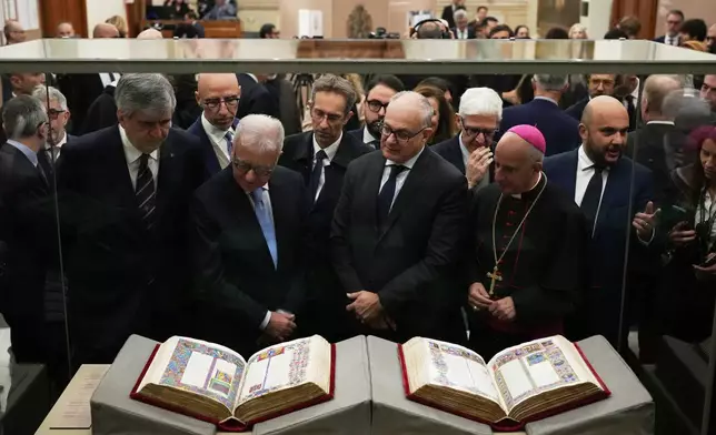 From right, Monsignor Rino Fisichella, Rome's Mayor Roberto Gualtieri and Italian government undersecretary Alfredo Mantovano look at the 15th century Borso D'Este Bible, comprising two illuminated manuscripts, after its unveiling at the Italian Senate as part of the Vatican's Holy Year celebrations in Rome, Thursday, Nov. 13, 2025. (AP Photo/Alessandra Tarantino)