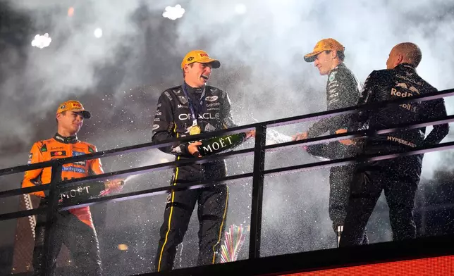 From left, second place finisher McLaren driver Lando Norris of Great Britain, first place finisher Red Bull driver Max Verstappen of the Netherlands, and third place finisher Mercedes driver George Russell of Great Britain celebrate after the Formula One Las Vegas Grand Prix auto race, Saturday, Nov. 22, 2025 in Las Vegas. (AP Photo/John Locher)