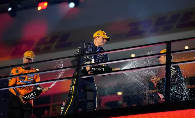 From left, second place finisher McLaren driver Lando Norris of Great Britain, first place finisher Red Bull driver Max Verstappen of the Netherlands, and third place finisher Mercedes driver George Russell of Great Britain celebrate after the Formula One Las Vegas Grand Prix auto race, Saturday, Nov. 22, 2025 in Las Vegas. (AP Photo/John Locher)