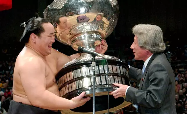 FILE - Grand Champion Asashoryu, left, is presented his champion trophy from Prime Minister Junichiro Koizumi following his victory at the Kyushu Grand Sumo Tournament in Fukuoka, southern Japan, on Nov. 27, 2005. (Kyodo News via AP, File)