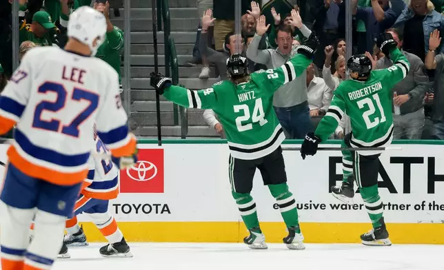 Dallas Stars left wing Jason Robertson (21) and center Roope Hintz (24) celebrate Robertson's goal during the second period of an NHL hockey game against the New York Islanders, Tuesday, Nov. 18, 2025, in Dallas. (AP Photo/Gareth Patterson)