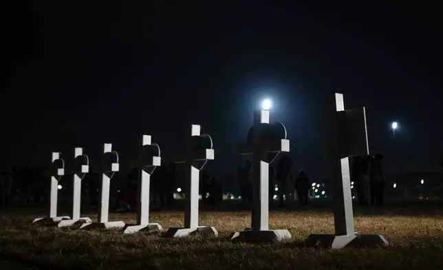 Crosses stand during a vigil for those killed and missing after a UPS plane crashed, at the Great Lawn, Friday, Nov. 7, 2025, in Louisville, Ky. (AP Photo/Jon Cherry)