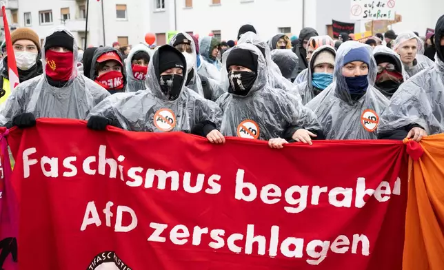 Demonstrators hold a banner that reads: "Bury Fascism - Smash the AfD", as thousands gather in Giessen, Germany, Saturday Nov. 29, 2025, as the far-right Alternative for Germany’s new youth organization is set to kick off its founding convention. (Boris Roessler/dpa via AP)
